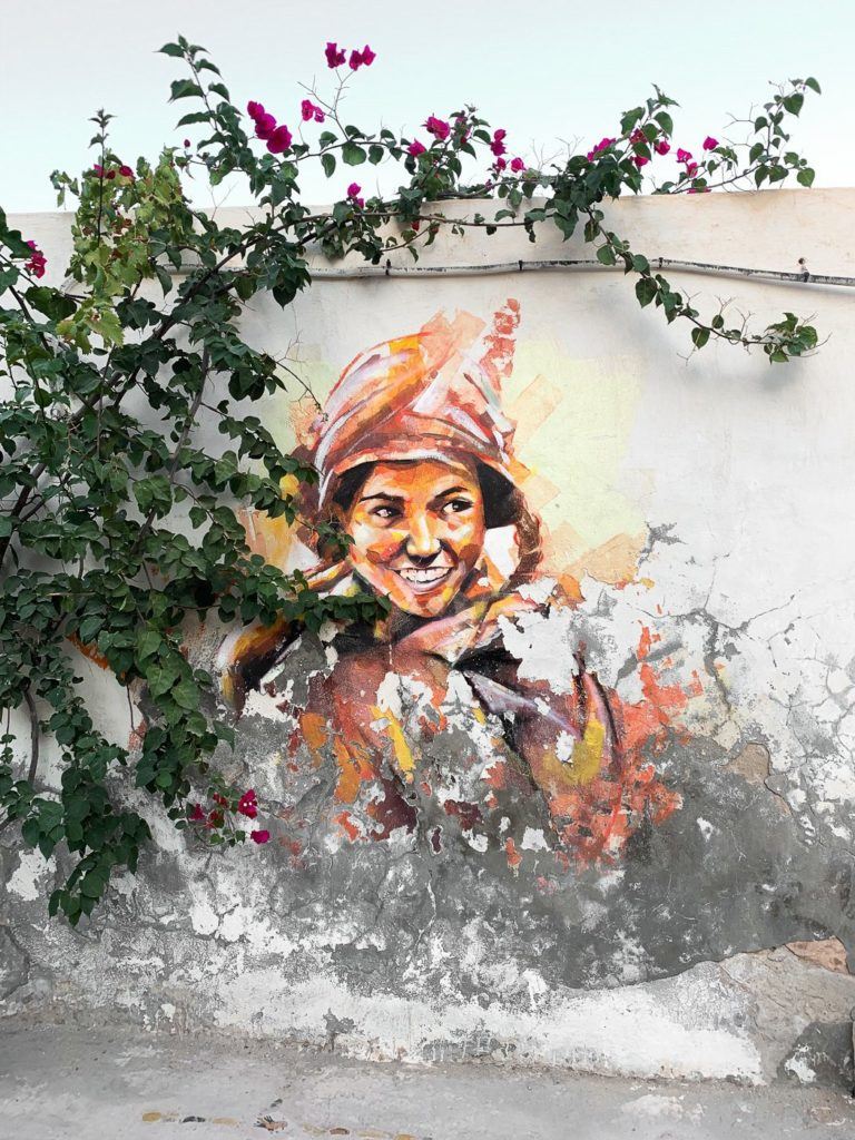 a painting of a woman on a wall.
