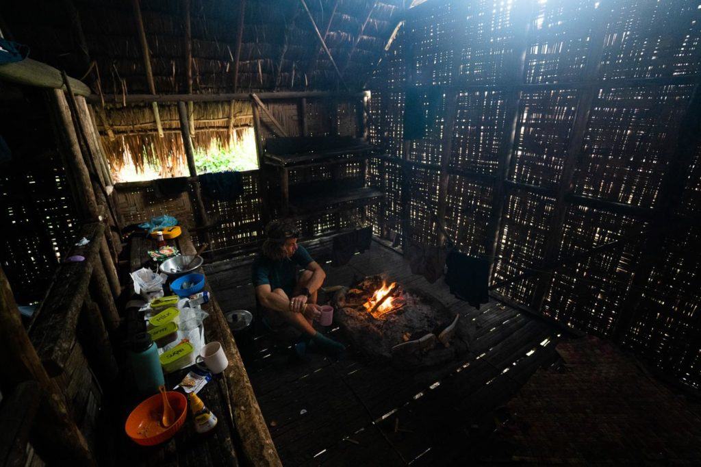 a man sitting on a couch next to a fire.