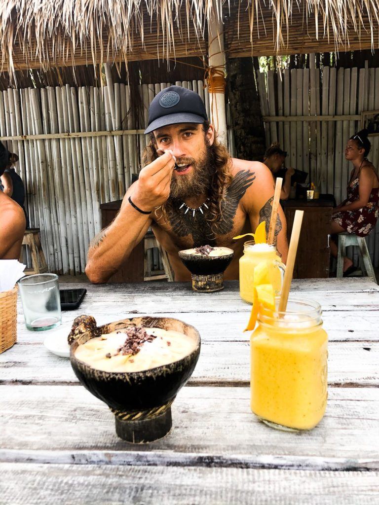 a man sitting at a table eating a bowl of food.