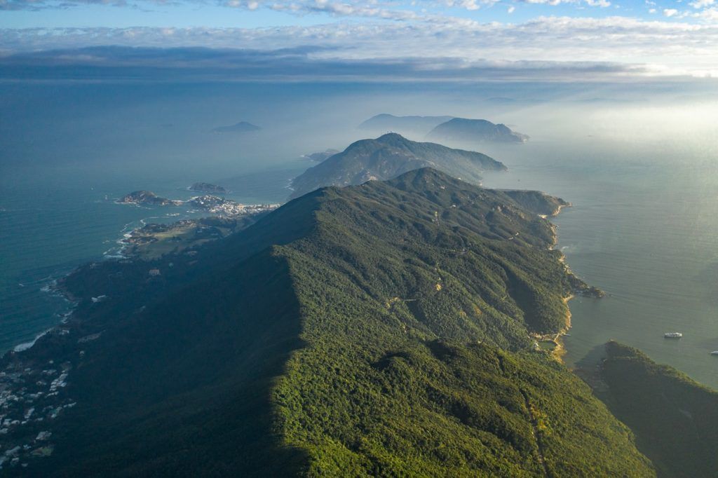 an aerial view of the ocean and mountains.