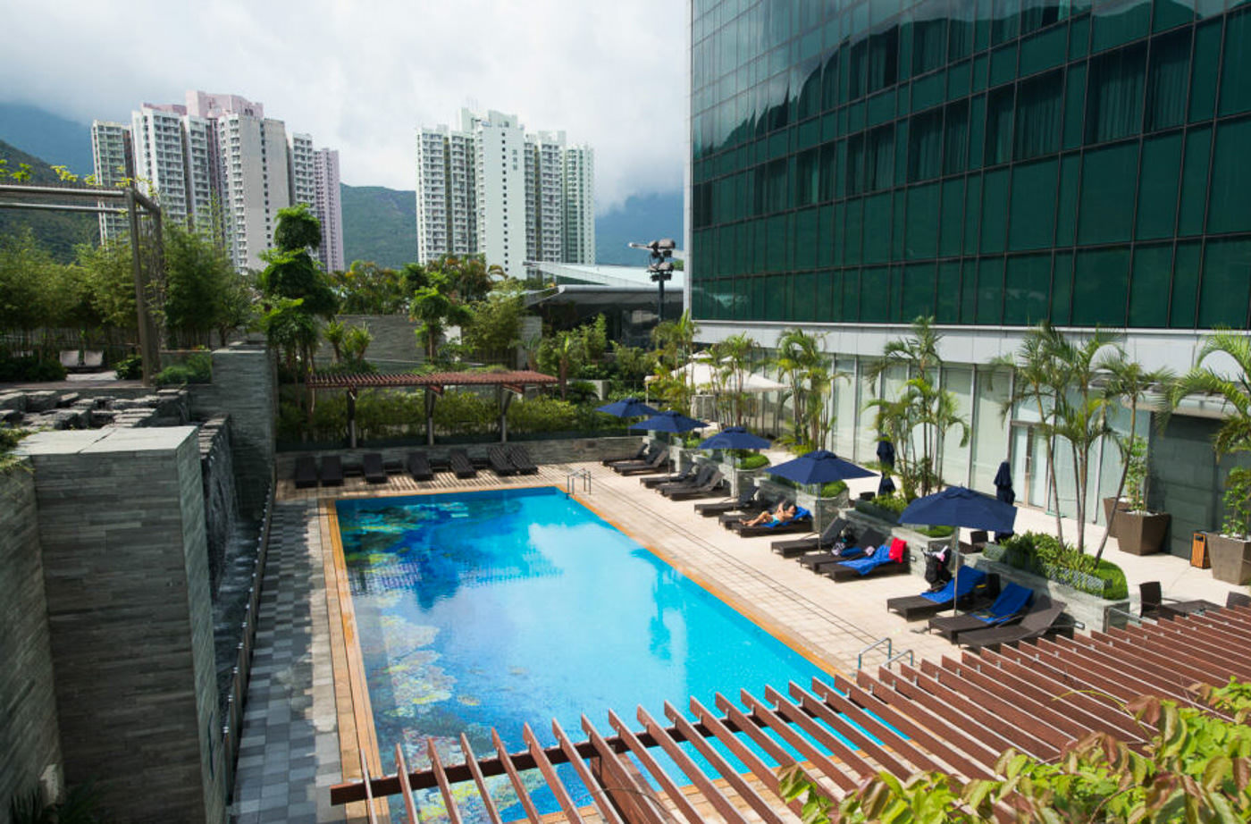 a swimming pool with lounge chairs and umbrellas.