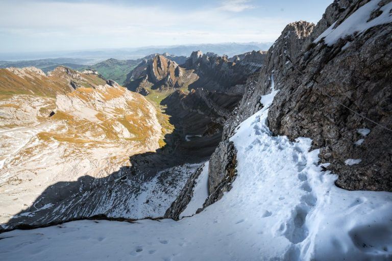 a person walking up a snow covered mountain.