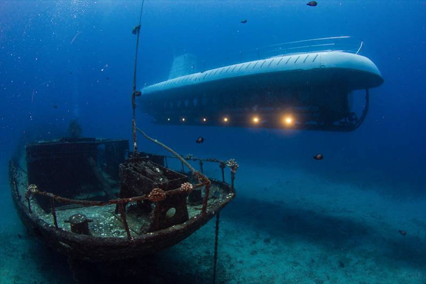 a submarine floating in the ocean next to a boat.