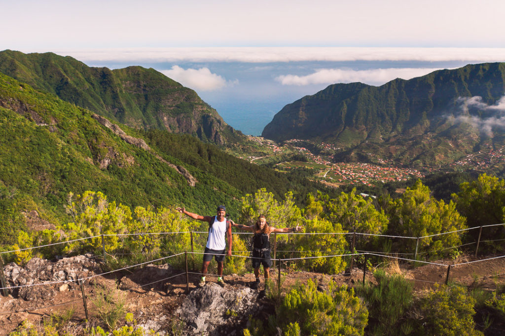 a man and a woman standing on top of a mountain.