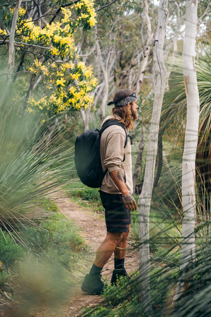 a man with a backpack walking down a path.