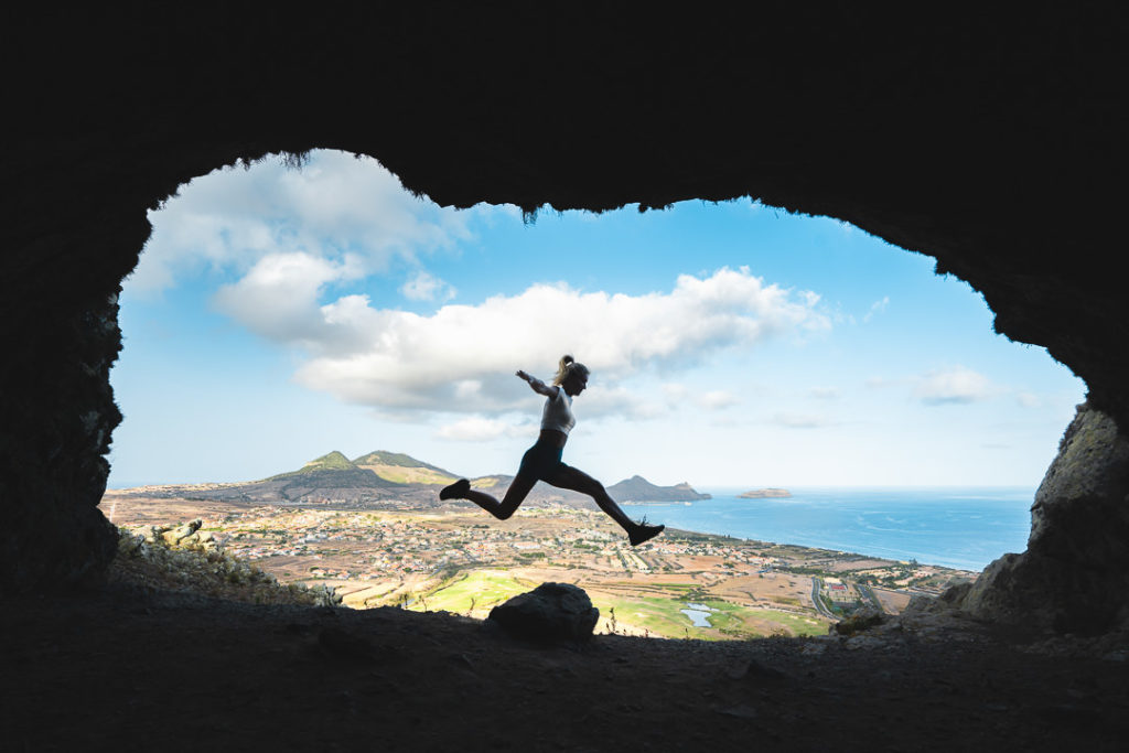 a person jumping in the air in a cave.