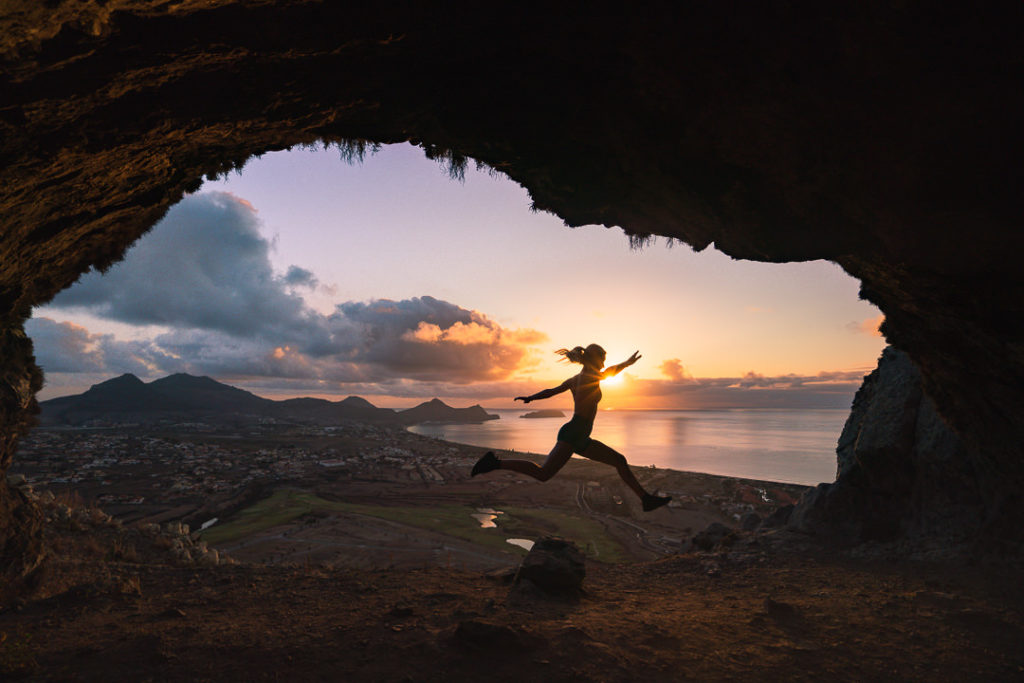 a person jumping in the air in front of a sunset.