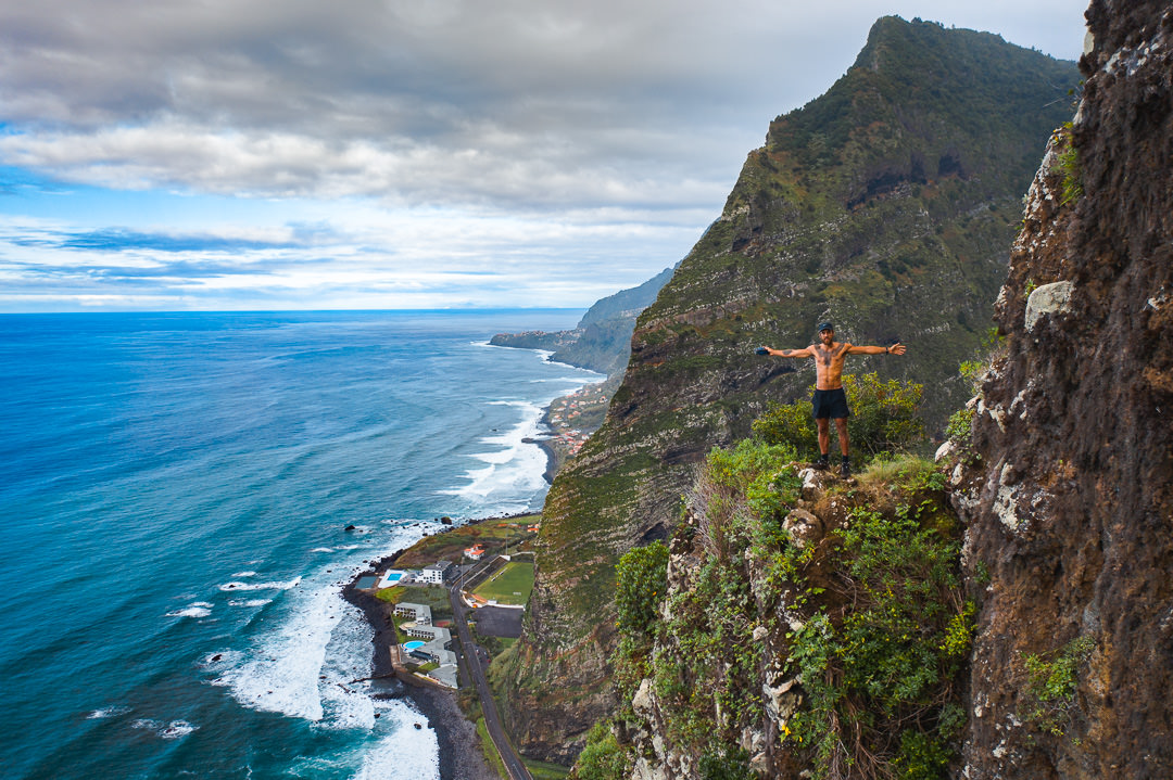 a man standing on the edge of a cliff overlooking the ocean.