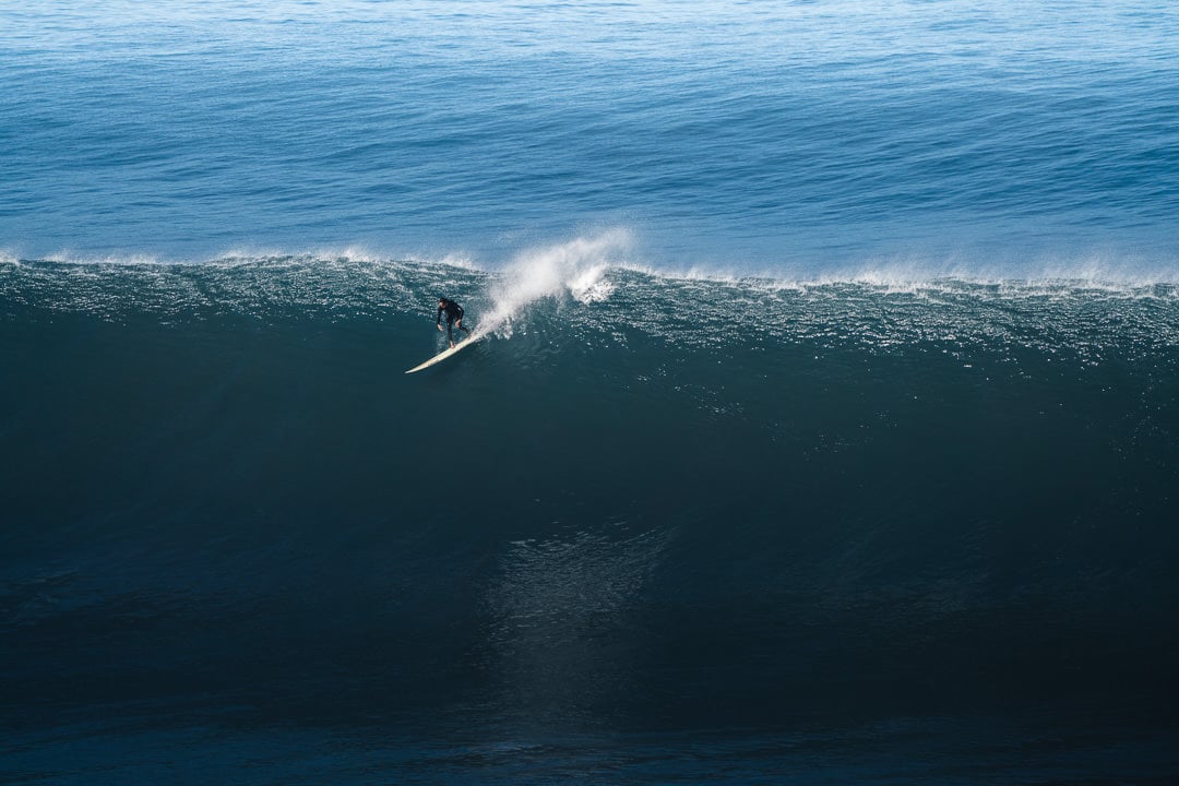 a man riding a wave on top of a surfboard.