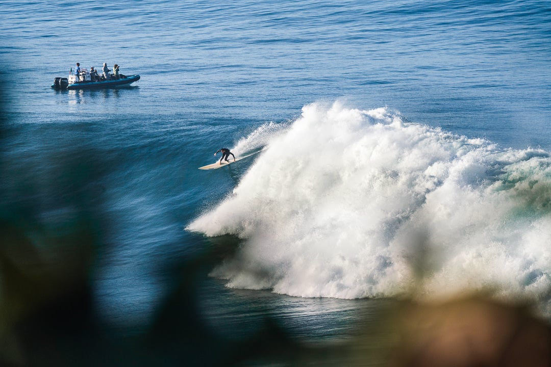 a man riding a wave on top of a surfboard.