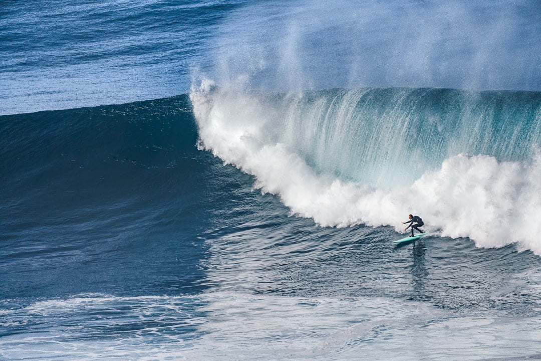 a person riding a wave on top of a surfboard.