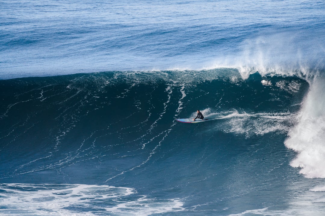 a man riding a wave on top of a surfboard.