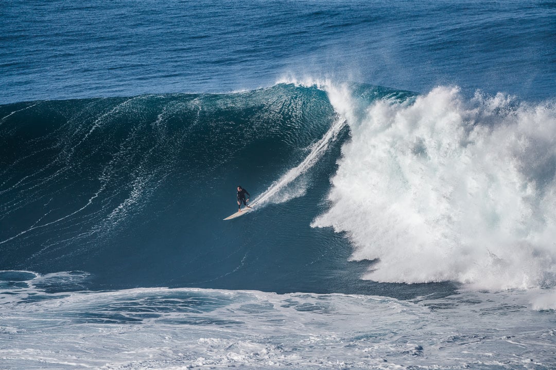 a man riding a wave on top of a surfboard.