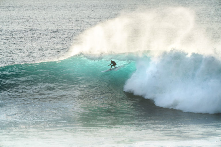 a person riding a wave on a surfboard.