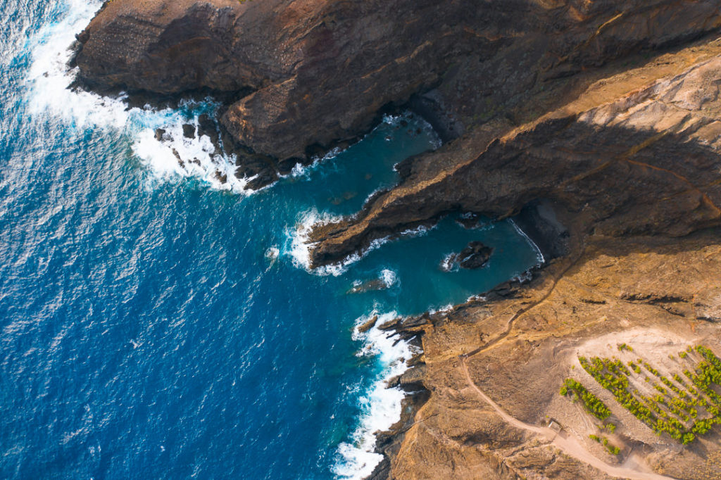 an aerial view of the ocean and cliffs.