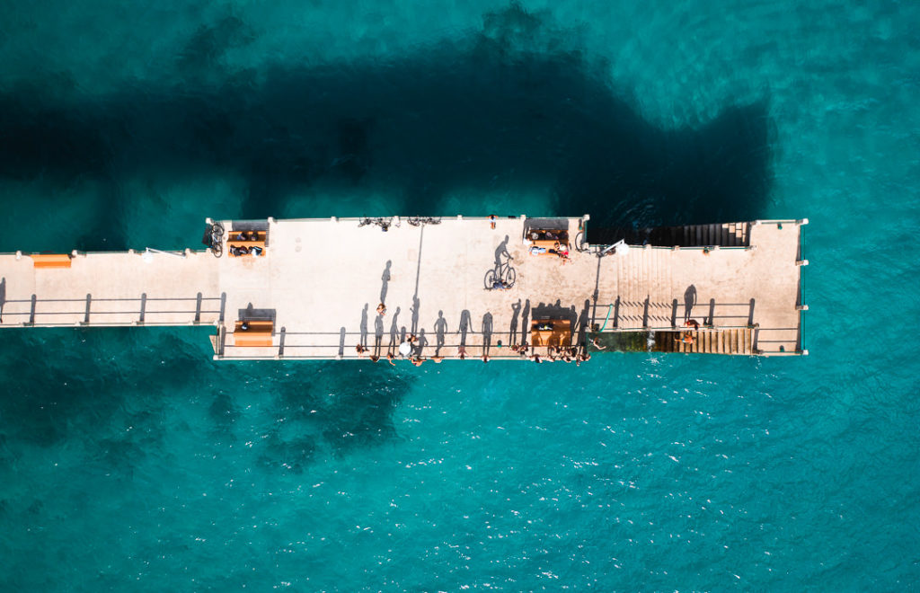 an aerial view of a pier in the middle of the ocean.