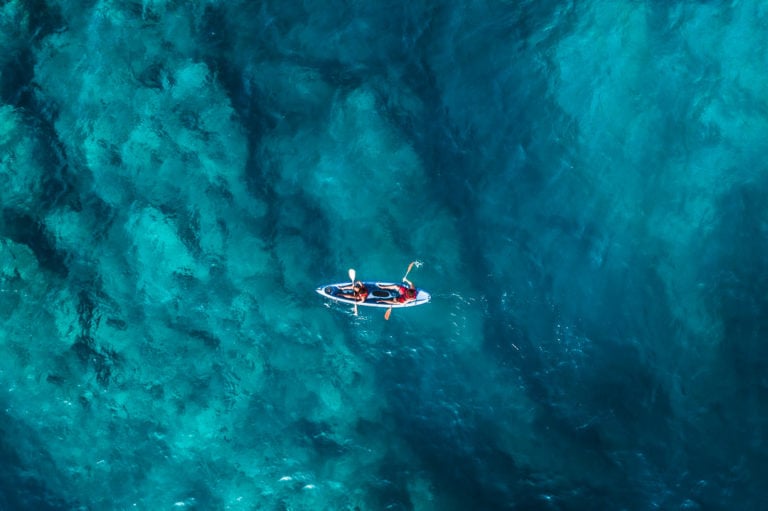 a person in a boat in the middle of a body of water.