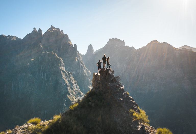 a group of people standing on top of a mountain.