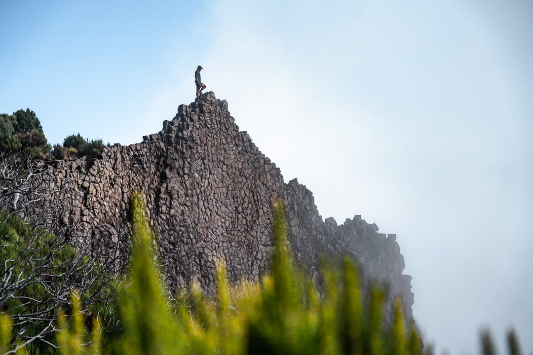 a man standing on top of a rocky mountain.