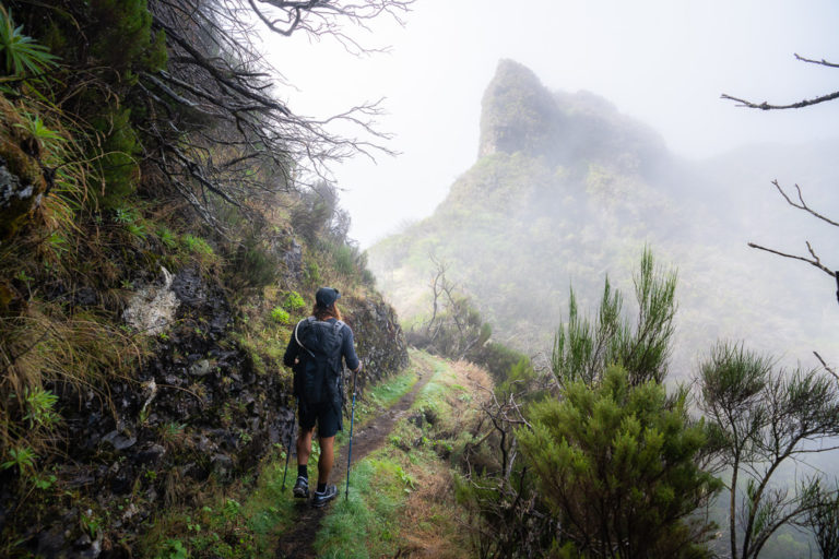 a person walking up a trail in the mountains.