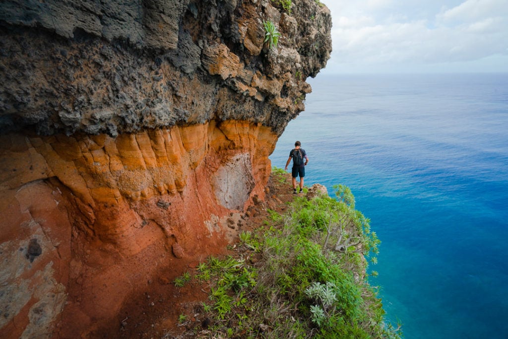 a man standing on the edge of a cliff overlooking the ocean.