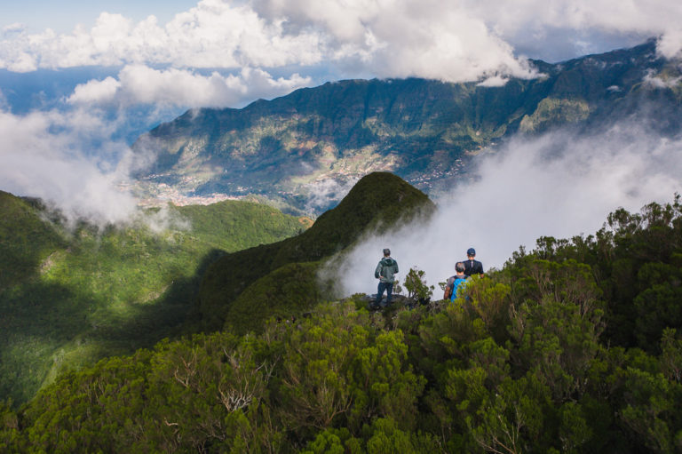 a group of people standing on top of a mountain.