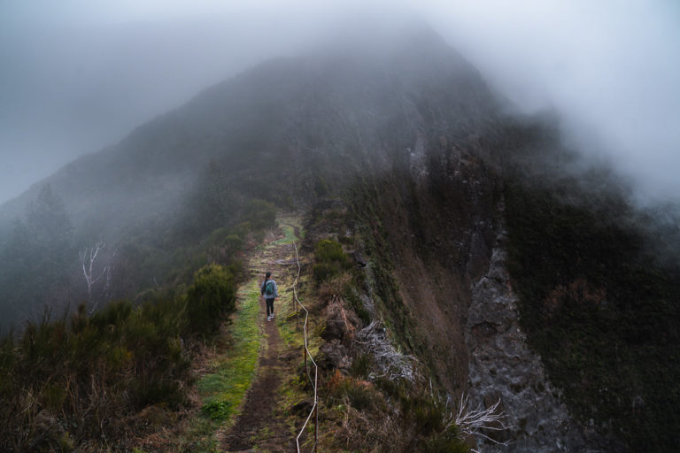 a person walking up a steep hill on a foggy day.