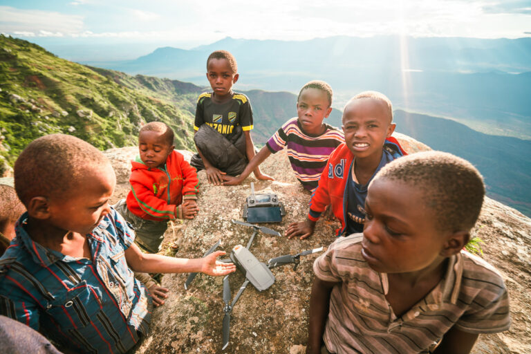 a group of children sitting on top of a mountain