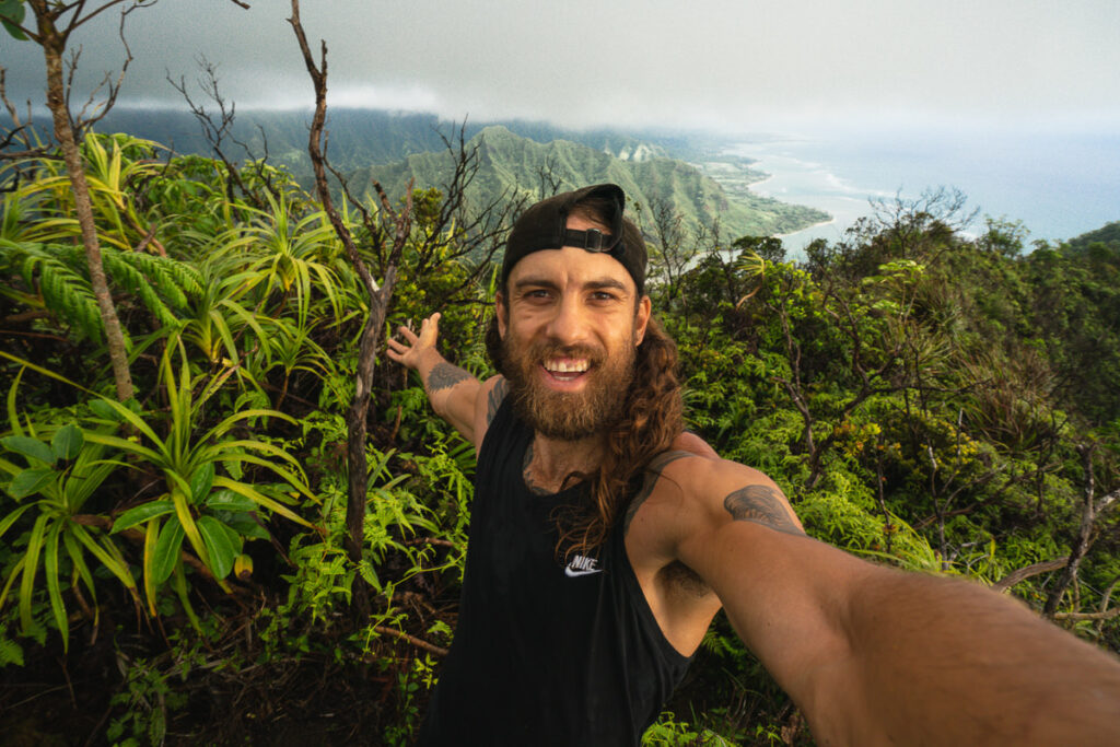 a man with long hair and a beard is taking a selfie
