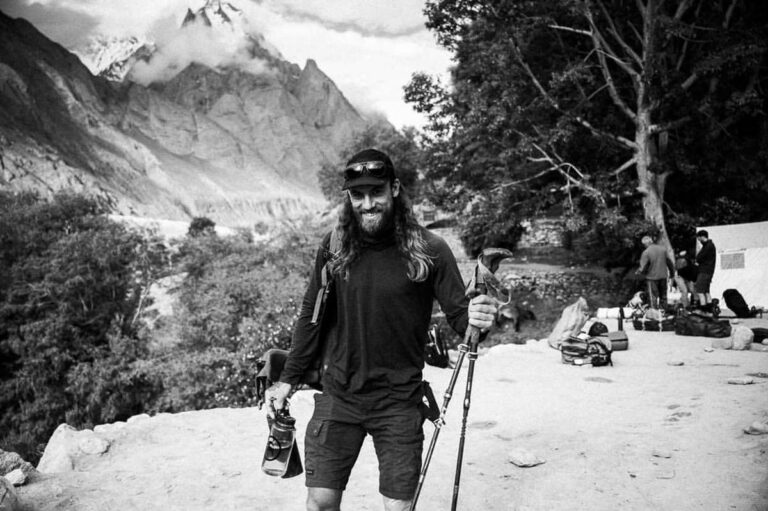 a man with long hair and beard wearing skis