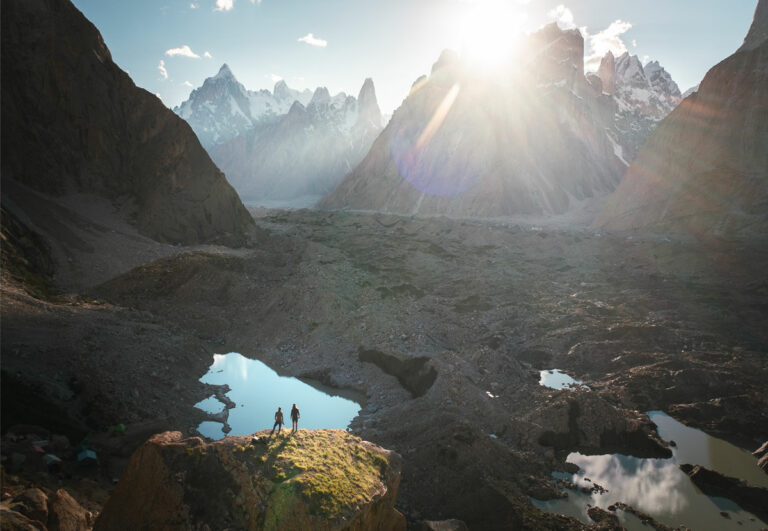 a couple of people standing on top of a mountain