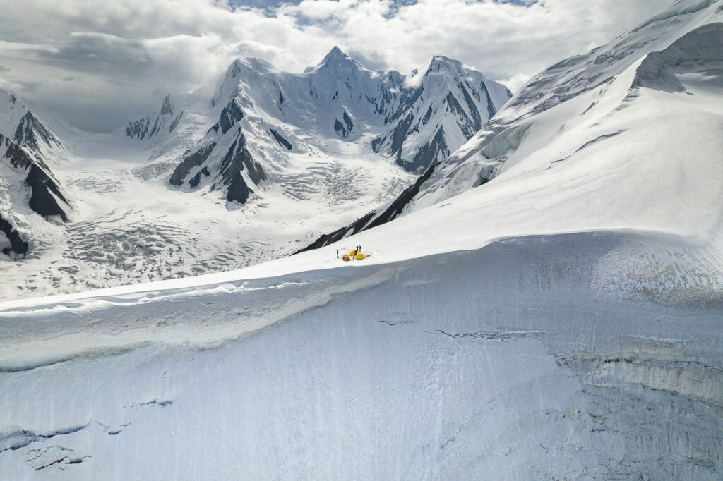 a person skiing down a snowy mountain with mountains in the background