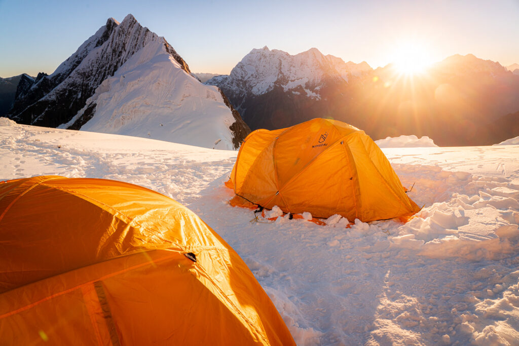 a couple of tents sitting on top of a snow covered ground