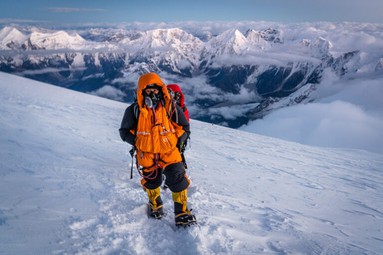 a man standing on top of a snow covered slope