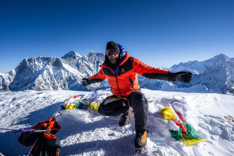 a man sitting on top of a snow covered mountain
