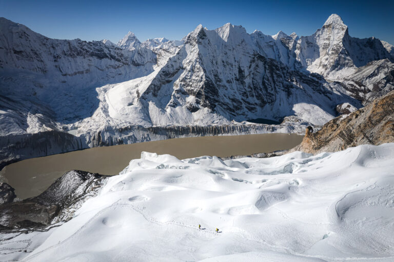a snow covered mountain with a lake in the middle