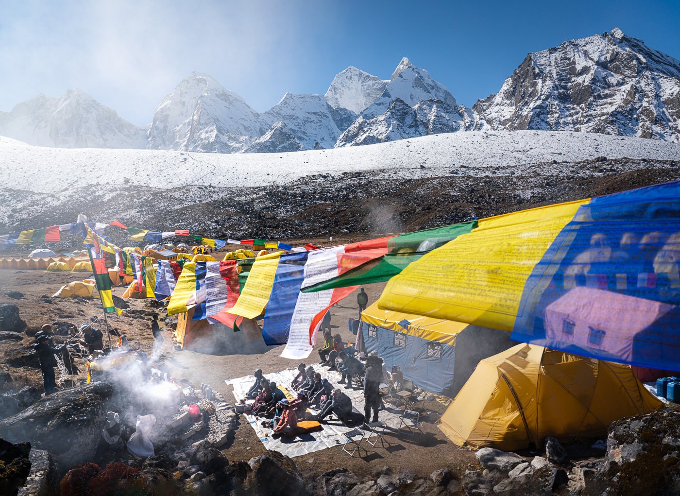 a group of people standing next to a mountain covered in snow