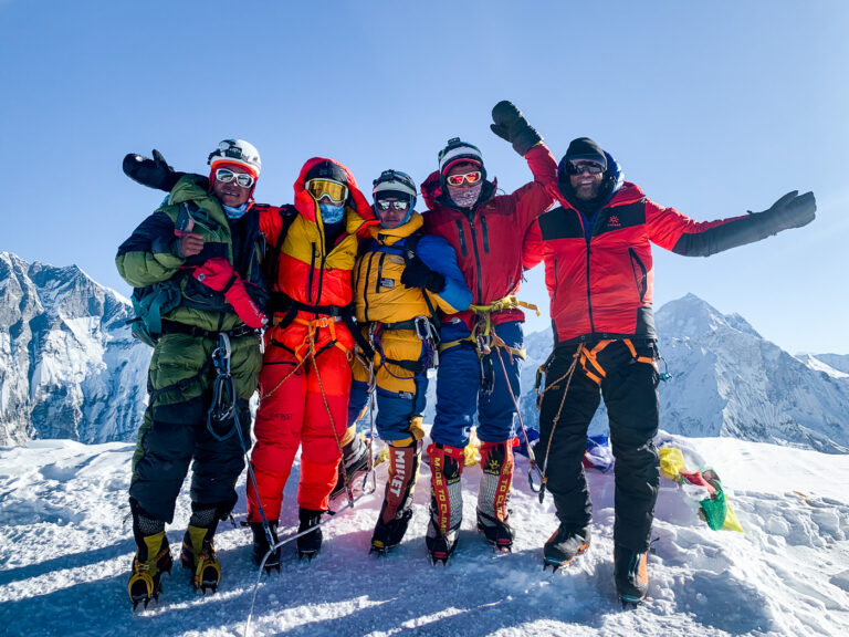 a group of people standing on top of a snow covered slope