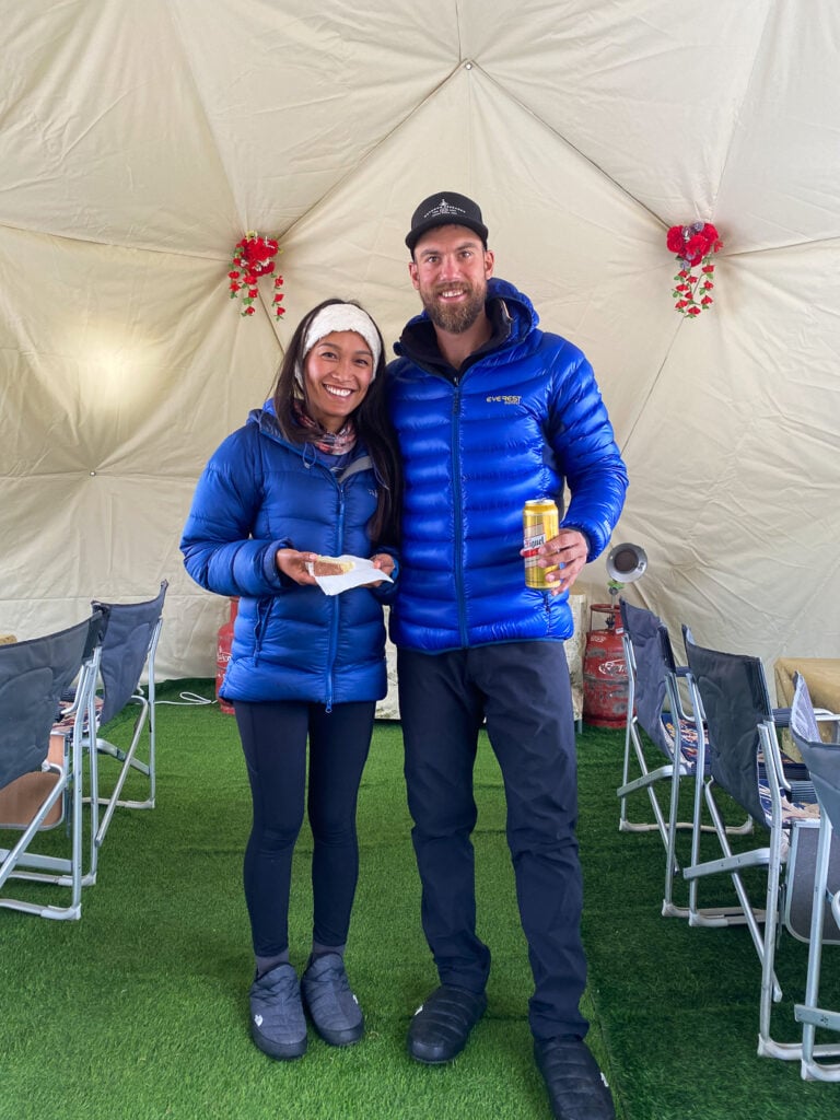 a man and a woman standing in front of a tent