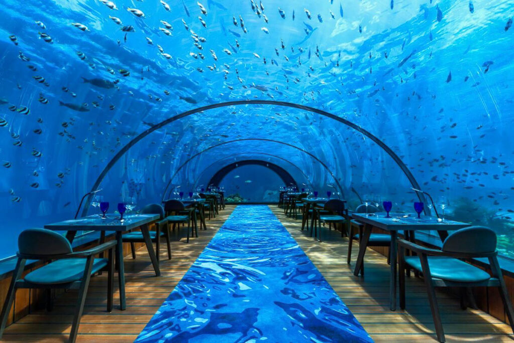 an underwater restaurant with tables and chairs under the water