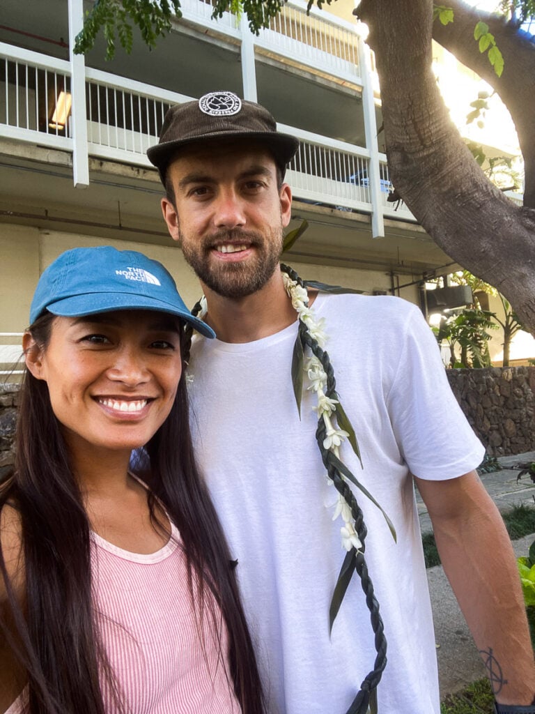 a man standing next to a woman under a tree