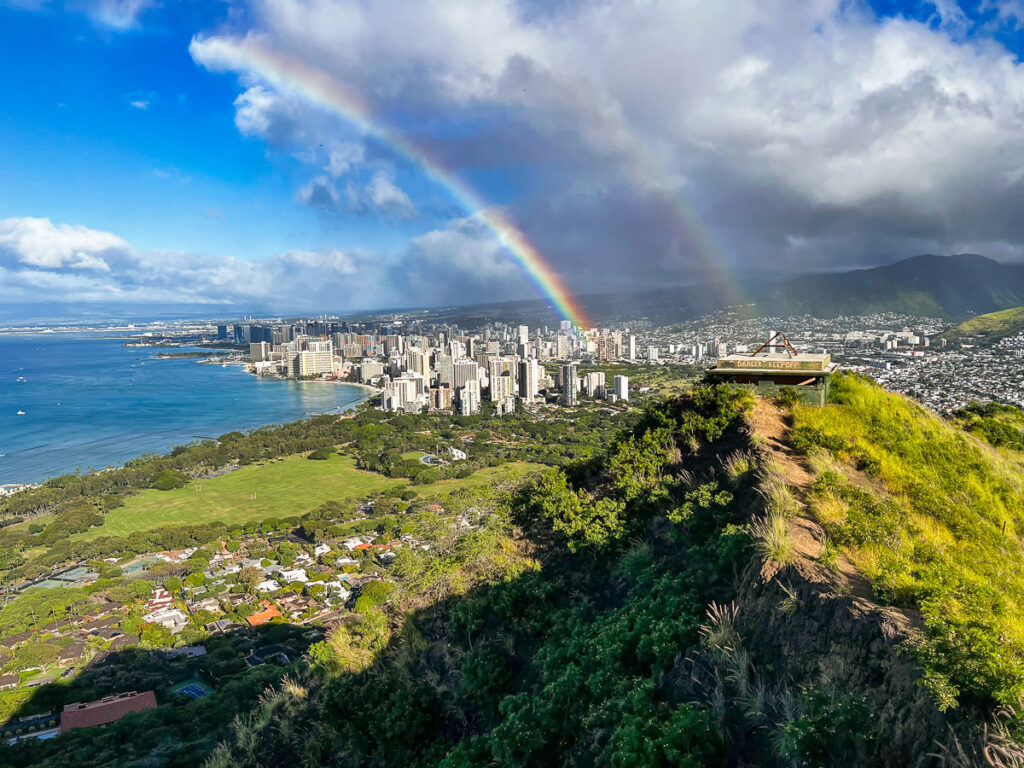 a rainbow is seen over a city on a hill