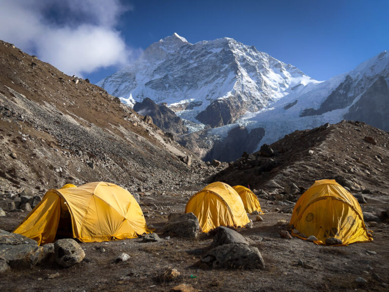 a group of yellow tents sitting on top of a mountain