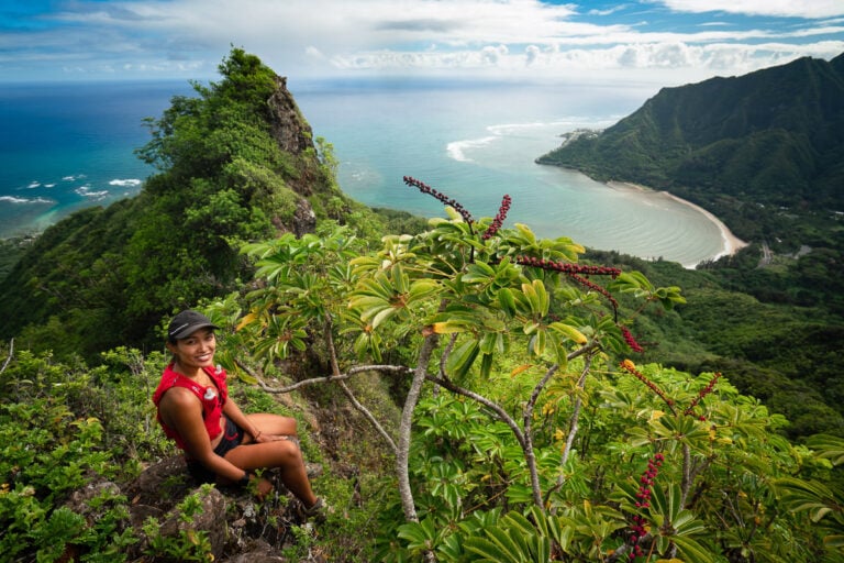 a woman sitting on a cliff overlooking the ocean