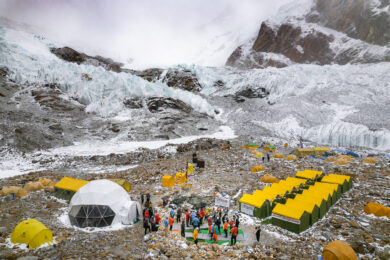 a group of people standing around tents in the snow