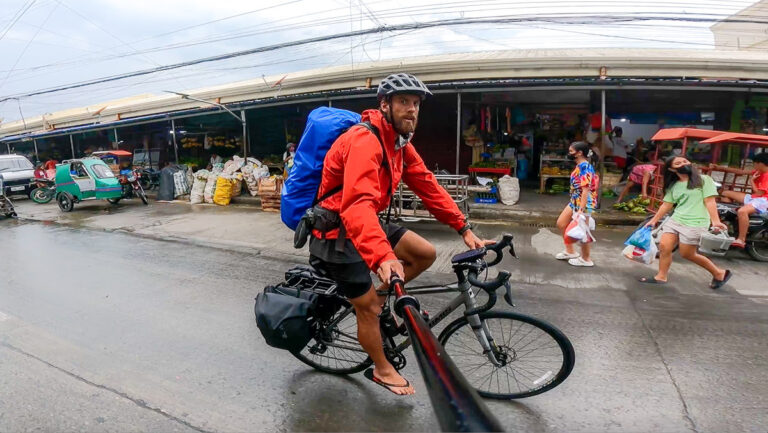 a man riding a bike down a rain soaked street