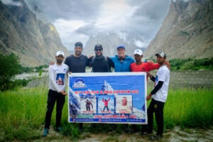 a group of men standing next to each other holding a sign