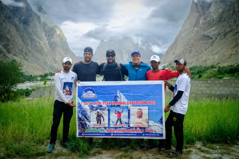 a group of men standing next to each other holding a sign
