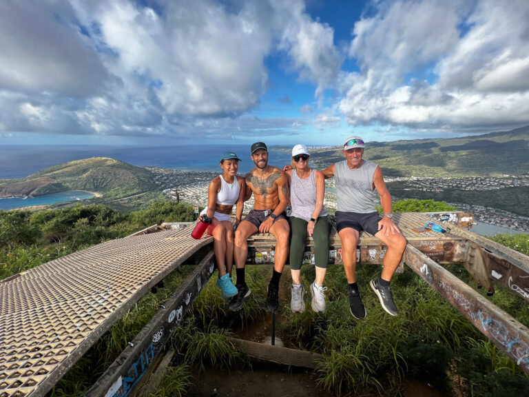a group of people sitting on top of a wooden bench