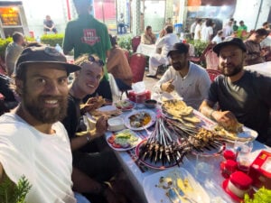 a group of people sitting around a table with food on it